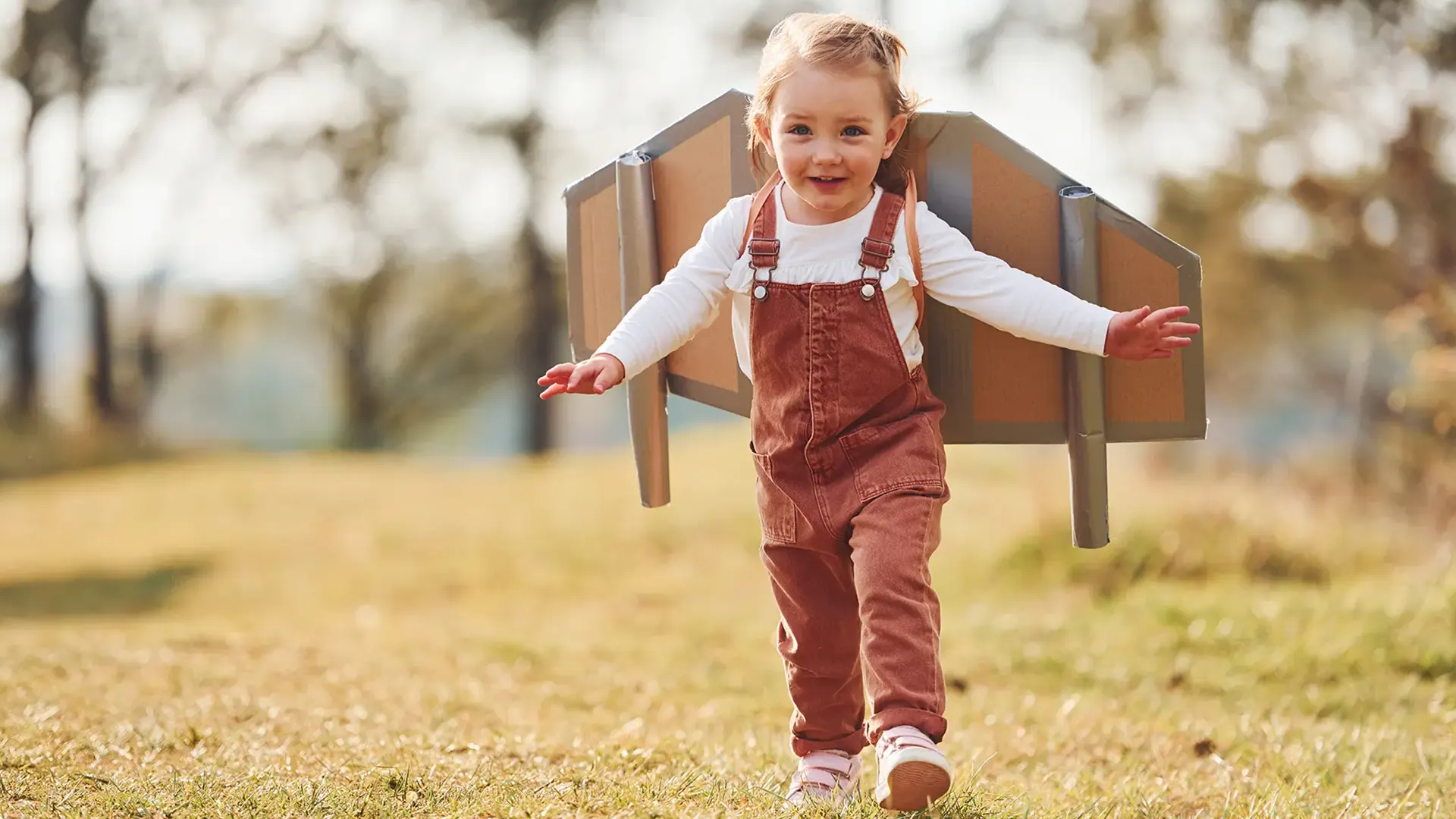cute-little-girl-with-handmaded-wings-running-outdoors-field-having-fun copy